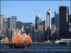 Традиционная рыбацкая лодка на фоне небоскребов Гонконга, Китай